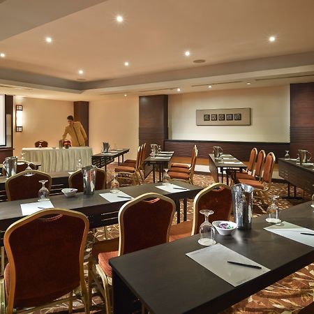 Parkroyal Penang Resort Batu Ferringhi Exterior photo The photo shows a conference room set up for a meeting or seminar. It features several tables arranged in a classroom or boardroom style, each equipped with chairs, stationery, glasses, and water pitchers. The room is well-lit with modern lighting an